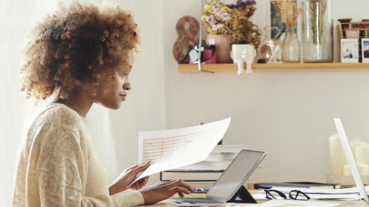 Woman at computer determining what to do with tax refund.