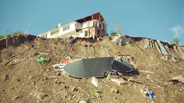 一座被地震毁坏的房子坐落在一座被废墟覆盖的山上.